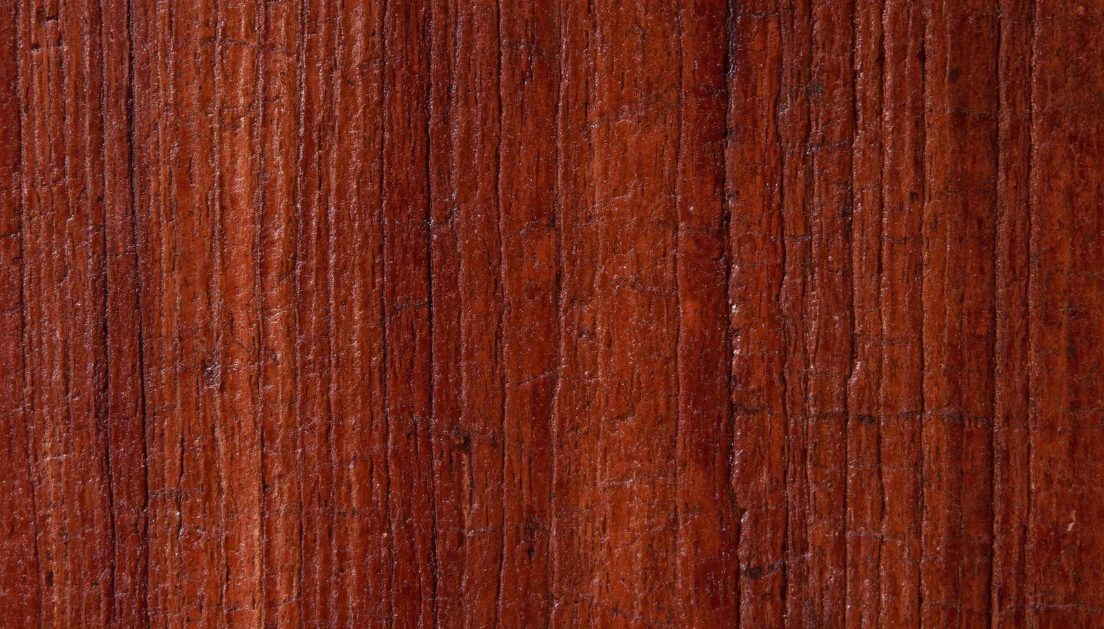 Close-up of reddish-brown mahogany wood grain on a bedroom dresser