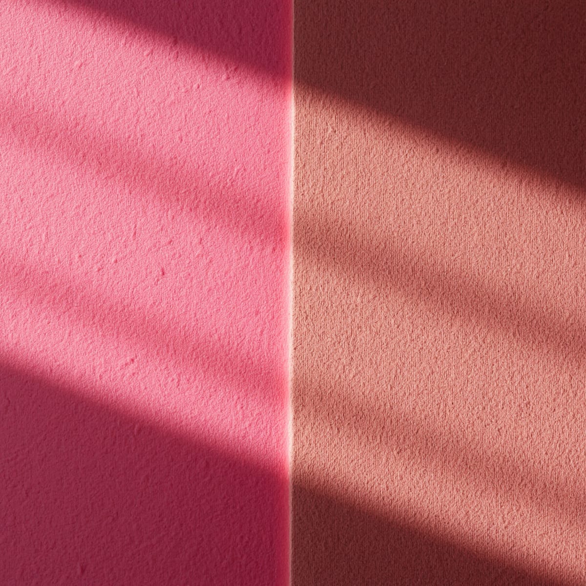 Candy pink swatch beside a dusty rose swatch under warm lamplight